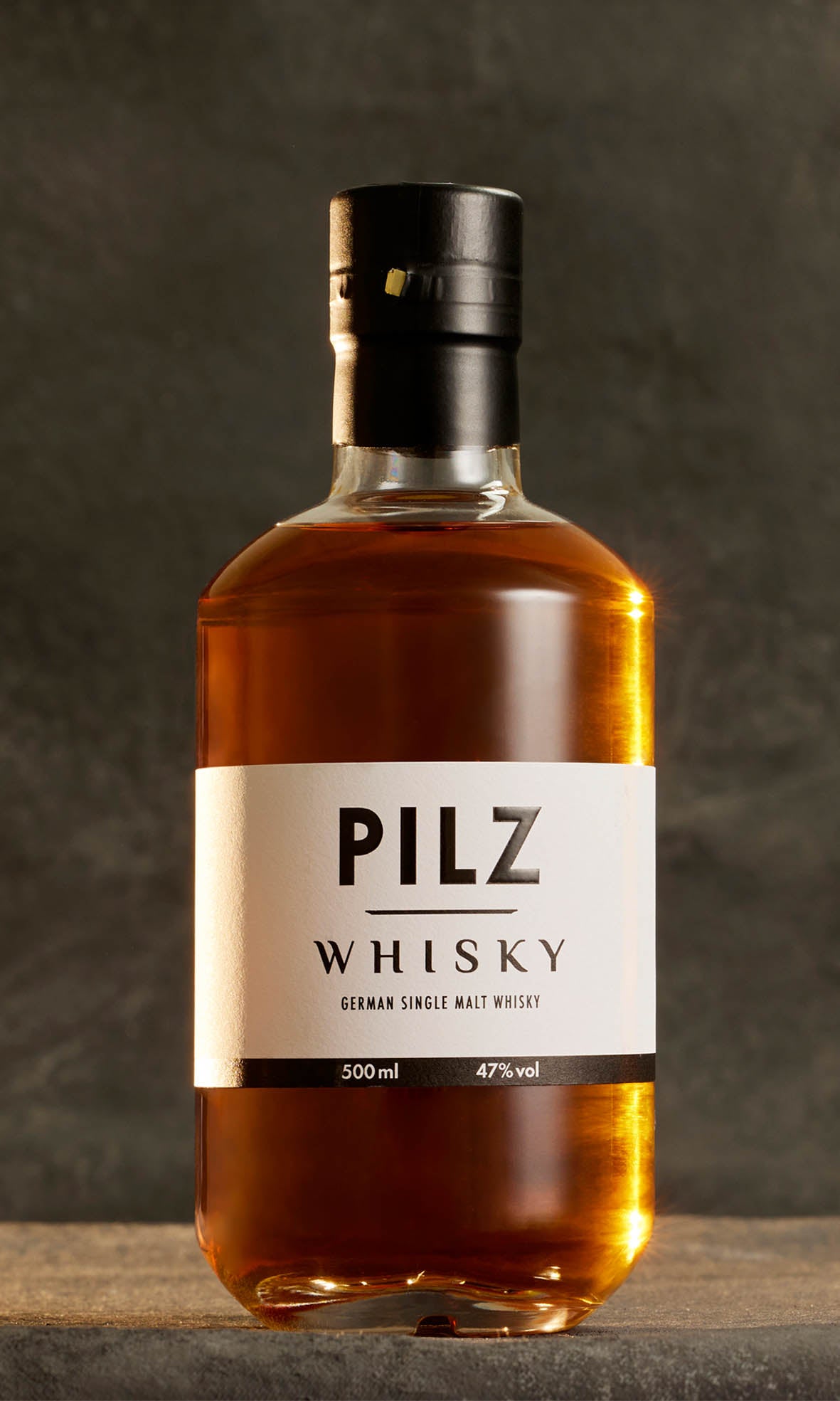 Flasche Pilz Whisky vor grauem Hintergurnd